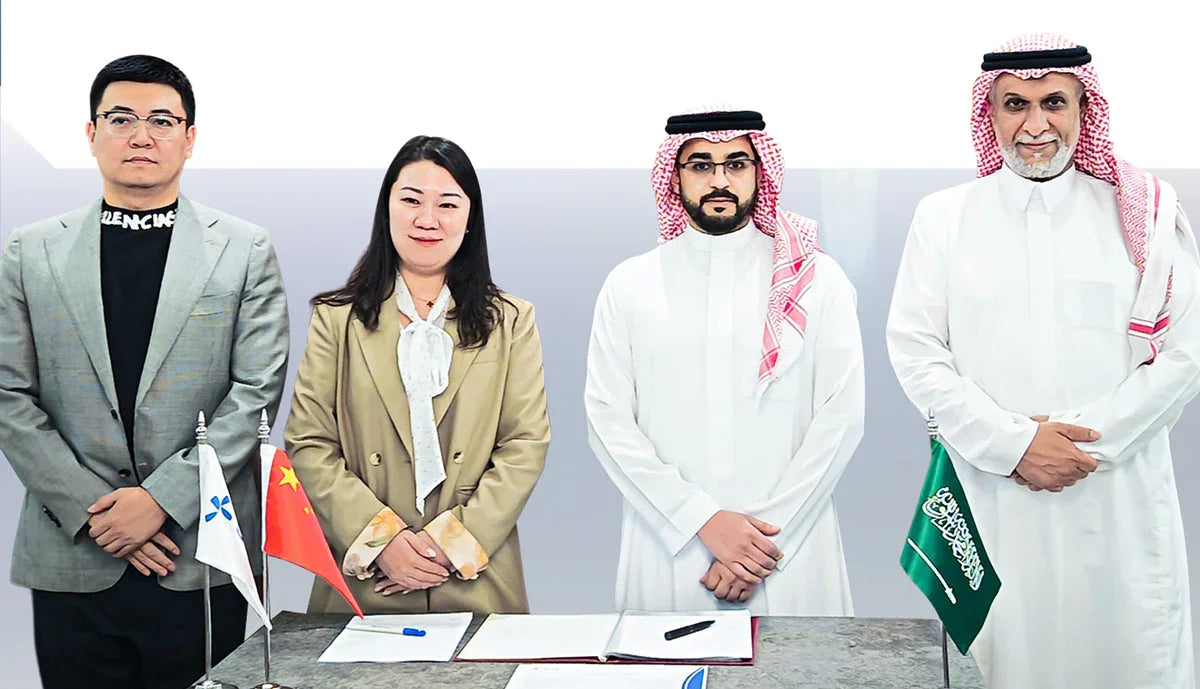 Saudi and Chinese business representatives standing together with national flags.