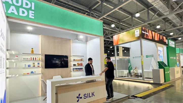 Silk United exhibition booth at a B2B trade show featuring product displays and staff.